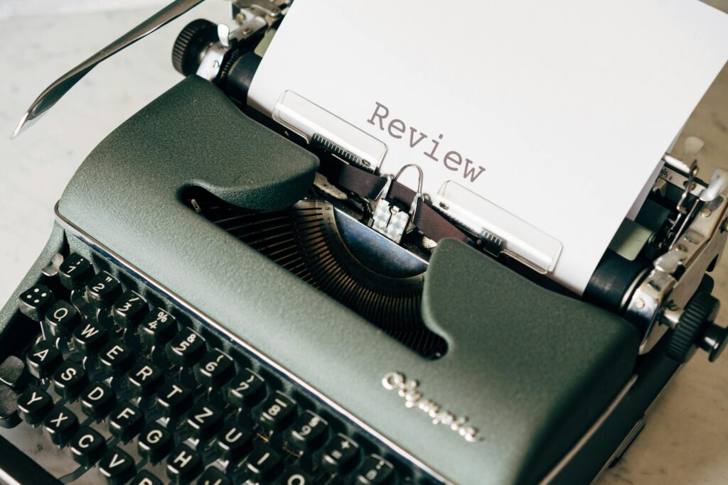 Classic green typewriter with paper displaying 'Review', perfect for creative writing themes.